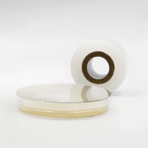 Microppose laboratory polyfilm roll resting next to a petri dish, highlighting the product's clarity and the sterile mycology environment it's used in.